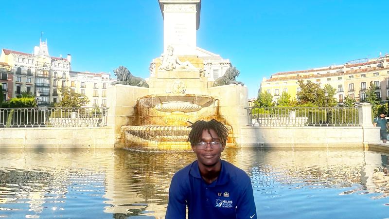 Picture of scholar sitting in front of fountain in Spain