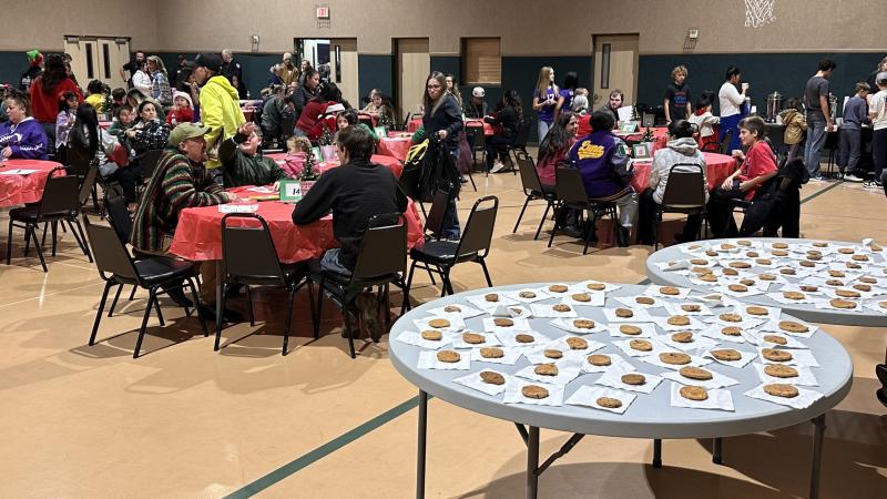 Families seated at tables during the district Christmas event